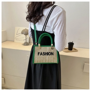 Détail d'un sac bandoulière en paille avec garniture en cuir vert et texte mode