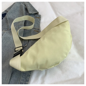 Top view of light green nylon crescent crossbody bag with adjustable strap and zip detail