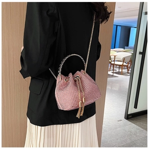 Pink rhinestone bucket bag with metal handle, drawstring closure and tassel detail