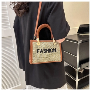 Détail du sac cabas en paille tissé main avec lanières en cuir brun et broderie fashion