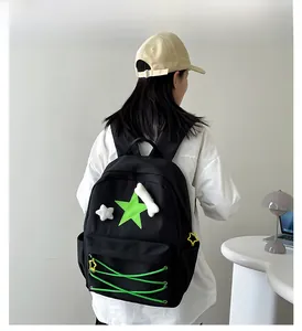 Detail of black backpack with green star patch and white star plush charms for students
