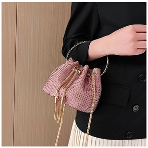 Detailed close-up of pink rhinestone bucket bag with golden ring handle and drawstring tassels
