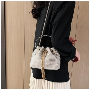 Detailed view of rhinestone bucket bag with golden ring handle and fringe drawstring
