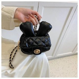 Detail showing the quilted black mini bag with rabbit ears and a golden chain strap