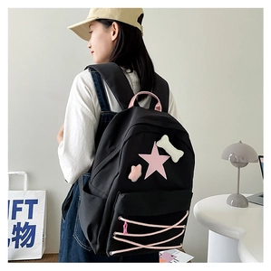 Detail of black star backpack with pink lace-up design and cute decorative patches
