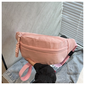 Close-up of pink nylon waist bag showing water-resistant fabric and zip pocket details