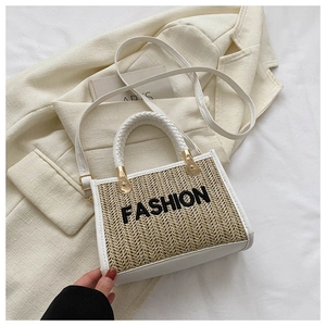 Détail du sac bandoulière en paille tissée avec bordure en cuir blanc et broderie fashion