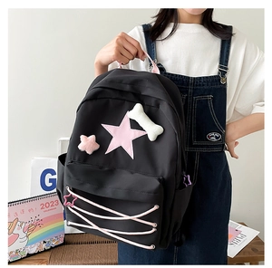 Detail of cute black star backpack with pink lace-up design and plush embroidery