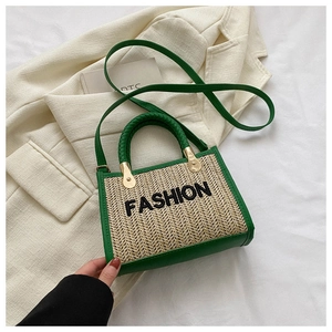 Vue détaillée du sac en paille avec bordure en cuir vert et broderie fashion devant