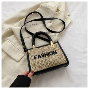 Détail de la broderie de lettres et bordure contrastée sur le sac bandoulière en paille