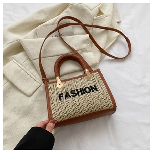 Détail d'un sac en paille tressée avec garniture en cuir et ferrures dorées sous un jour doux