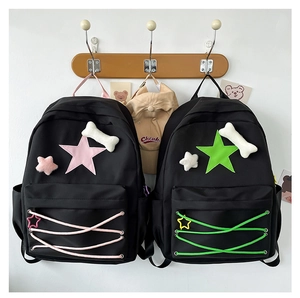 Detail of star-patterned backpacks with plush bone charms and cross-braided cords