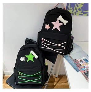 Detail showing two black nylon star backpacks with pink and green accents and bone charms