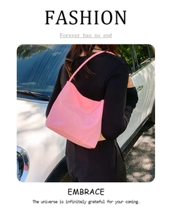 Close-up of pink nylon hobo bag featuring embossed textures and slim shoulder strap