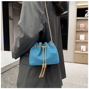 Close-up of sparkling blue bucket bag with rhinestones and elegant gold chain strap