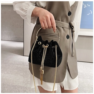Detail of black drawstring bucket bag with sparkling rhinestones and golden ring handle