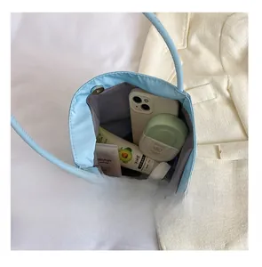 Spacious interior of light blue nylon bag showing storage for phone and cosmetics
