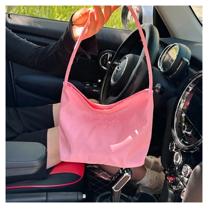 Pink nylon hobo bag with 'Onwards and upwards' embroidery detail in car interior