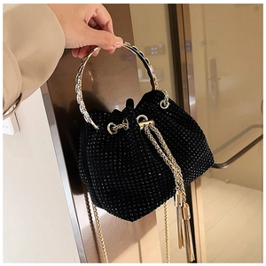 Detail of black rhinestone bucket bag with gold handle and drawstring chain tassels