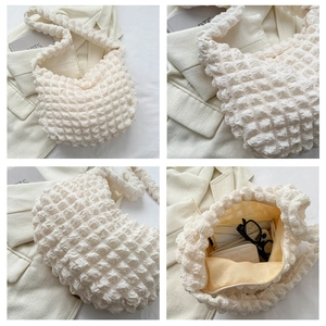 Detailed macro view of cream popcorn texture fabric and interior storage of shoulder bag