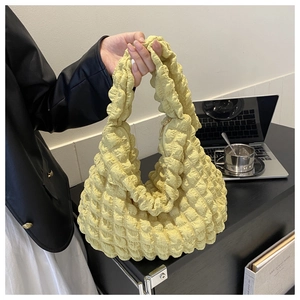 Detailed view of yellow popcorn textured fabric and metal zipper on the casual tote bag