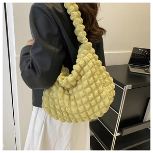 Detail of yellow quilted bubble fabric hobo bag showing textured popcorn pleats on shoulder