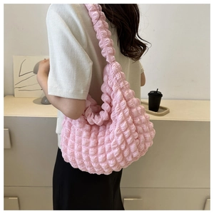 Detail view of pink bubble cloud shoulder bag with textured pleats on a fashion model
