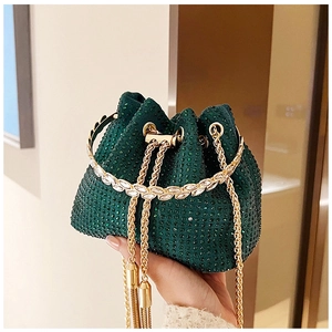 Close-up of emerald green velvet bucket bag with sparkling rhinestones and leaf handle