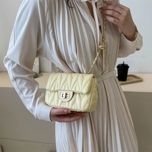 Elegant beige quilted shoulder bag with gold chain strap and metallic twist lock
