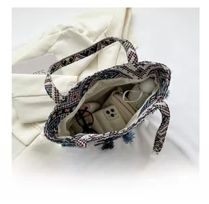 Detail show of large bohemian woven tote bag interior with tassel and ethnic pattern