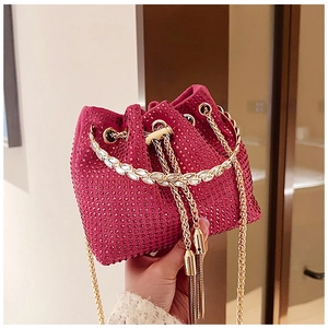 Detail of magenta bucket bag with sparkling rhinestones, gold chain, and metal tassels