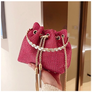 Close-up of pink bucket bag with sparkling rhinestones and golden tassel drawstring