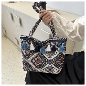 Detail of colorful geometric jacquard pattern and boho tassels on the canvas tote bag