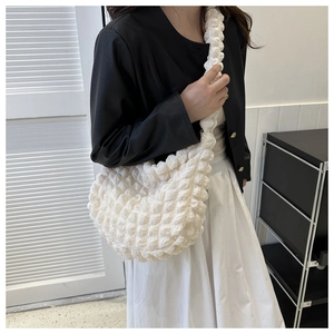 Detail of white popcorn textured cloud bag with quilted bubble fabric and crescent shape