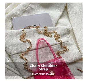 Détail du sac à bandoulière en PVC rose transparent avec sa bandoulière chaîne dorée