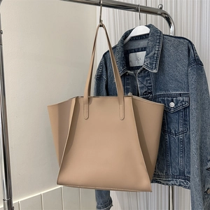 Bolso tote beige minimalista con detalle de pliegue geométrico lateral y asas finas de cuero