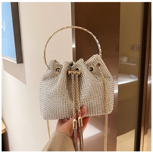 Close-up of sparkling rhinestone bucket bag with gold ring handle and tassel details
