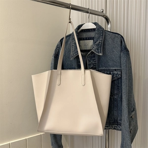 Detalle de bolso tote grande minimalista en color crema fabricado en cuero mate