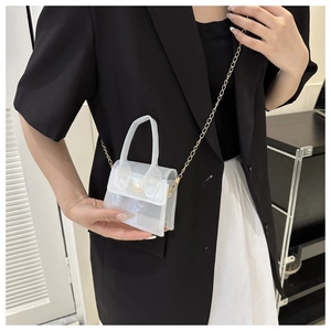 Modèle montrant la mini taille de ce sac bandoulière en PVC blanc nacré translucide