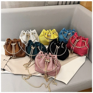 Detailed macro shot of rhinestone bucket bags showing multiple colors and metal chain straps