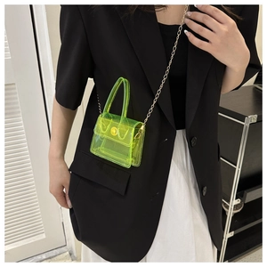 Mini sac transparent vert néon en PVC avec chaîne dorée porté sur une veste de blazer