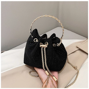 Detail of black rhinestone bucket bag with golden metal ring handle and tassel drawstring