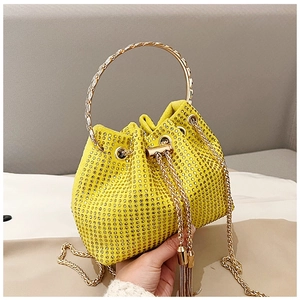 Detail of yellow rhinestone bucket bag with gold ring handle and chain strap closeup