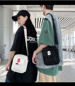 Detalle de los pequeños bolsos bandolera cuadrados de nailon blanco y negro con logo S 3D