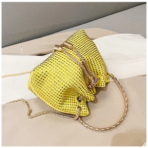 Detailed macro view of yellow rhinestones on bucket bag with gold ring handle and chain