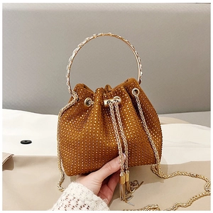 Close-up of brown suede bucket bag with gold rhinestones and metal handle