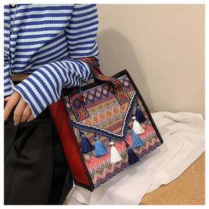 Dettaglio della borsa etnica bohémien con motivi geometrici colorati e nappe decorative