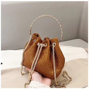 Detail of a brown drawstring bucket bag with gold rhinestones and a metal handle