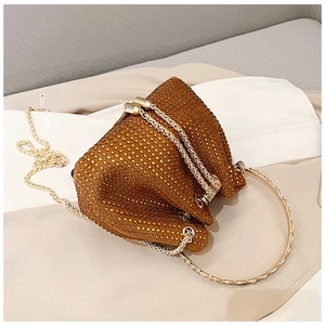 Close-up of golden sparkling evening bucket bag with rhinestone details and ring handle