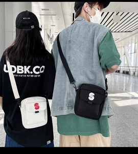 Estilo urbano de pareja con mini bolsos bandolera de nailon en blanco y negro con el logo S